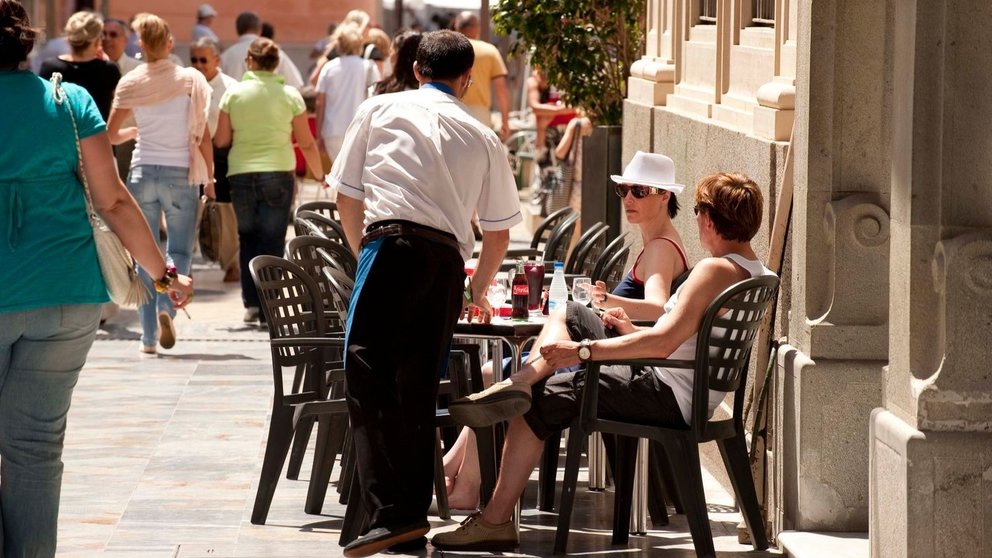 Un camarero atiende la terraza de un establecimiento en el centro de la ciudad.