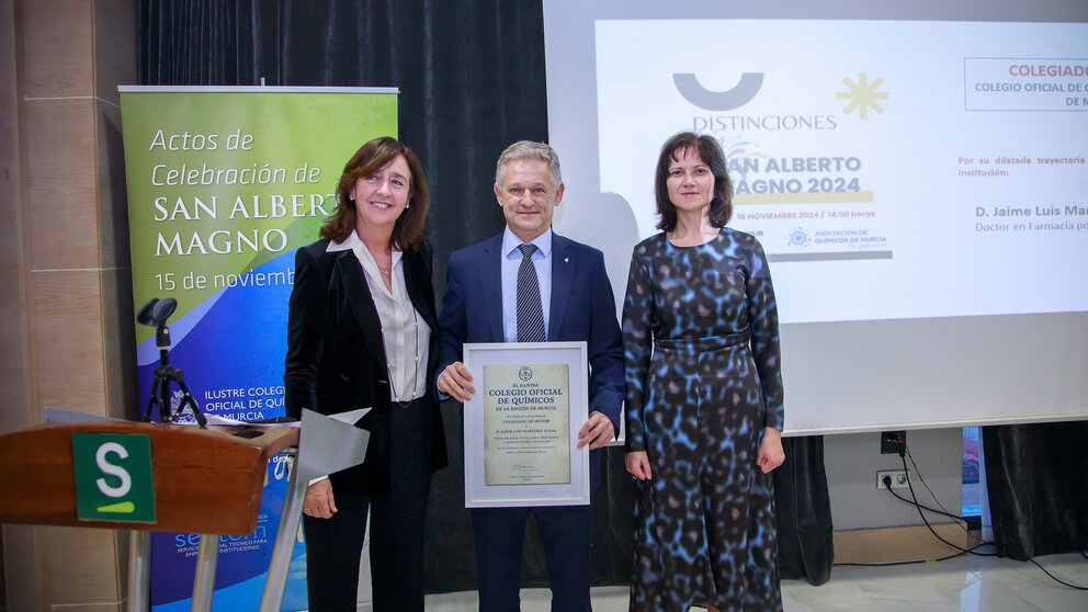 La Decana-Presidenta, Fuensanta Máximo, y la Secretaria, Maria Isabel Aguilar, entregando la distinción San Alberto Magno 'Colegiado de Honor' a Jaime Luis Martínez. (Colegio Oficial de Químicos de la Región de Murcia)