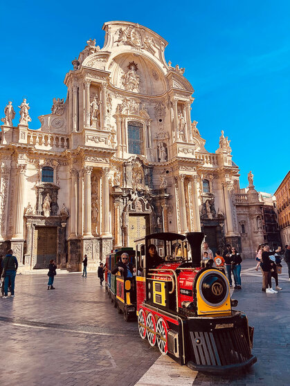 Un trenecito pasea turistas por la plaza de Cardenal Belluga, junto a la Catedral.