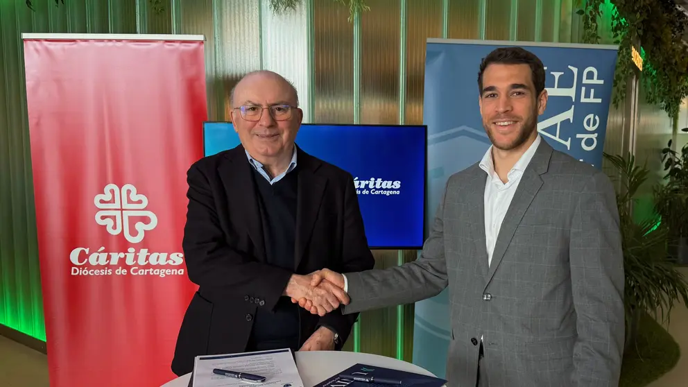 El director de Cáritas, José Antonio Planes, y el director de Operaciones de Universae, Miguel Sieteiglesias, firman el convenio de colaboración entre ambas instituciones. (Universae)