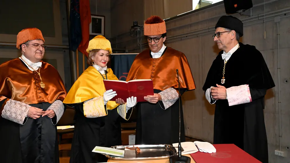 María Trinidad Herrero, madrina del honoris causa, hace entrega a Gil del libro, simbolo de la ciencia en el ceremonial de investidura. (UMU)